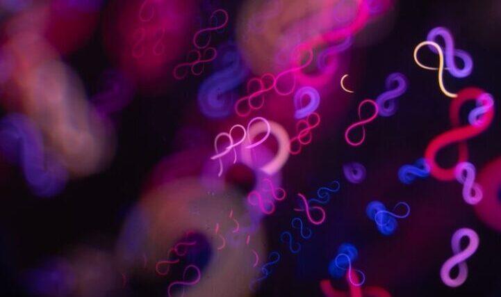 Abstract infinity symbols in neon pink and blue lights.