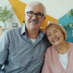 Elderly couple smiling together on a couch.
